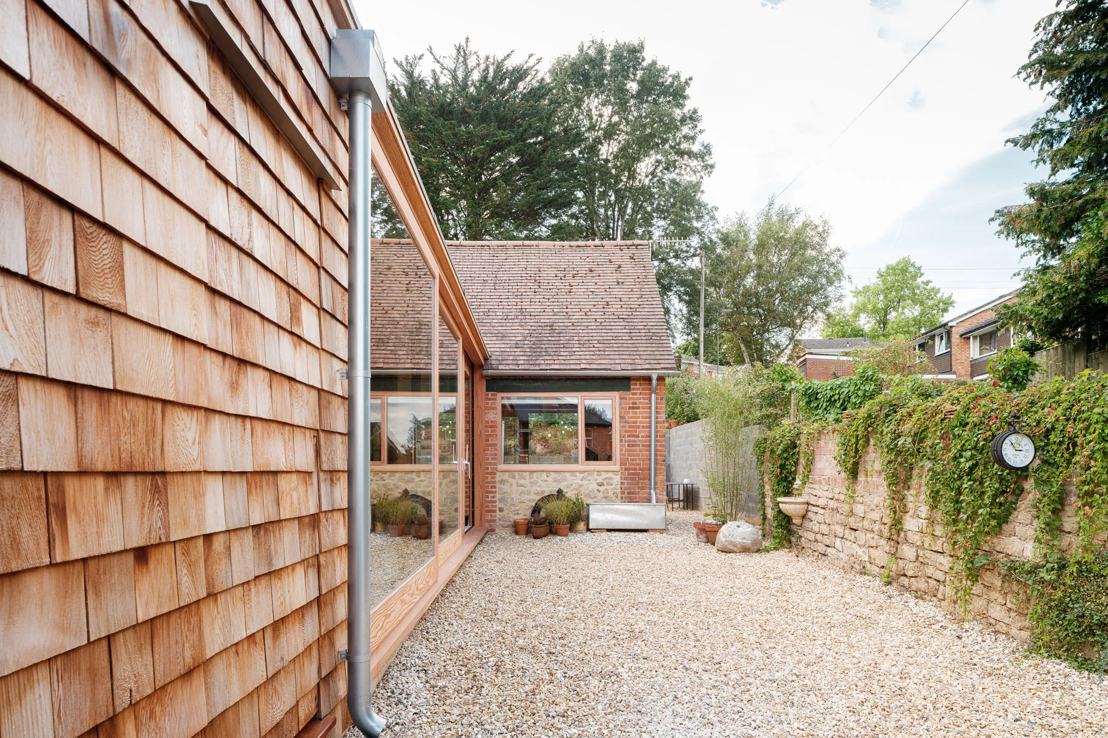 A series of lightweight timber framed extensions to retrofit an existing stone haybarn in Godalming, Surrey to create a new family home.